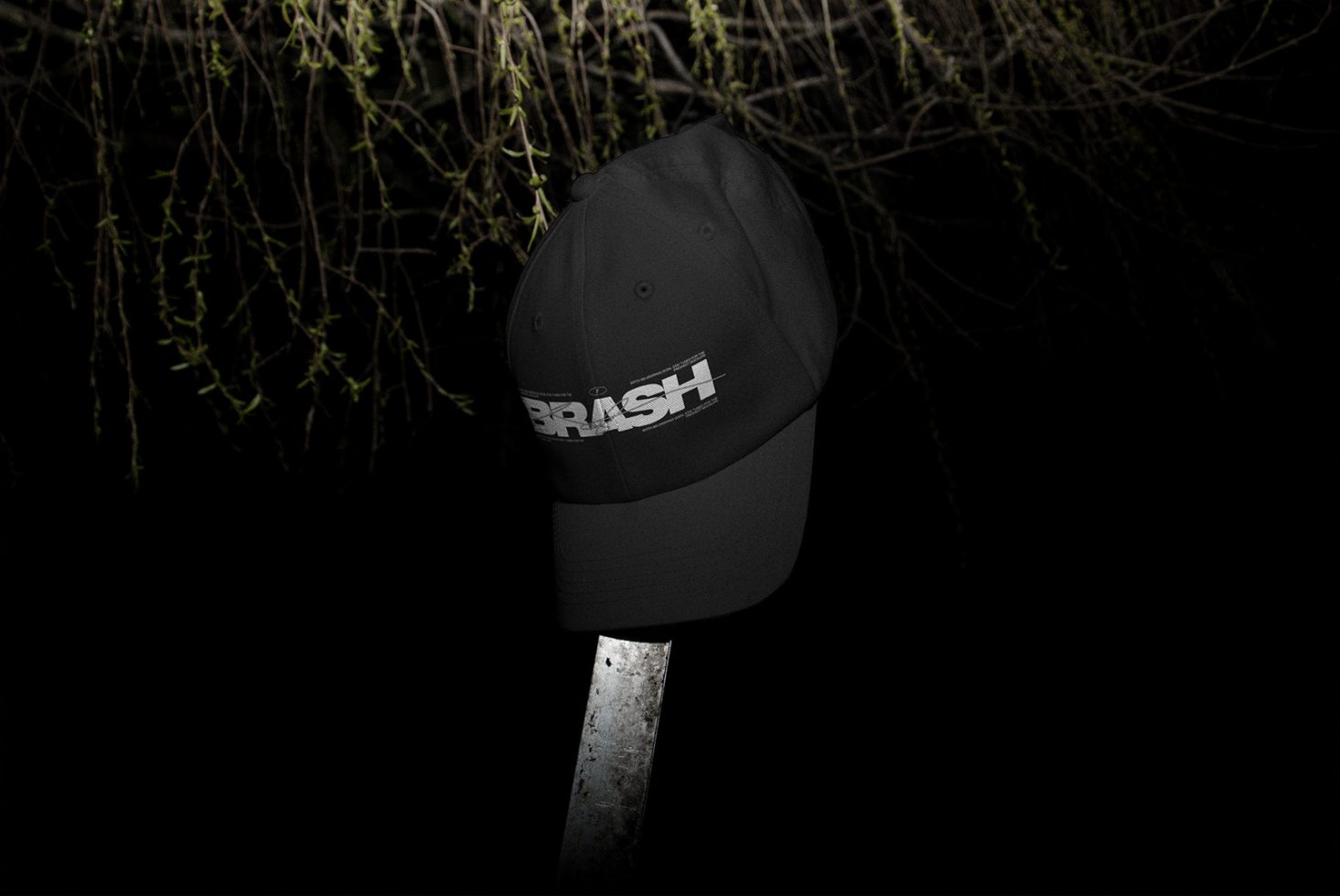 Black baseball cap mockup with white logo on post at night, realistic apparel design presentation, dark moody theme for graphic designers.